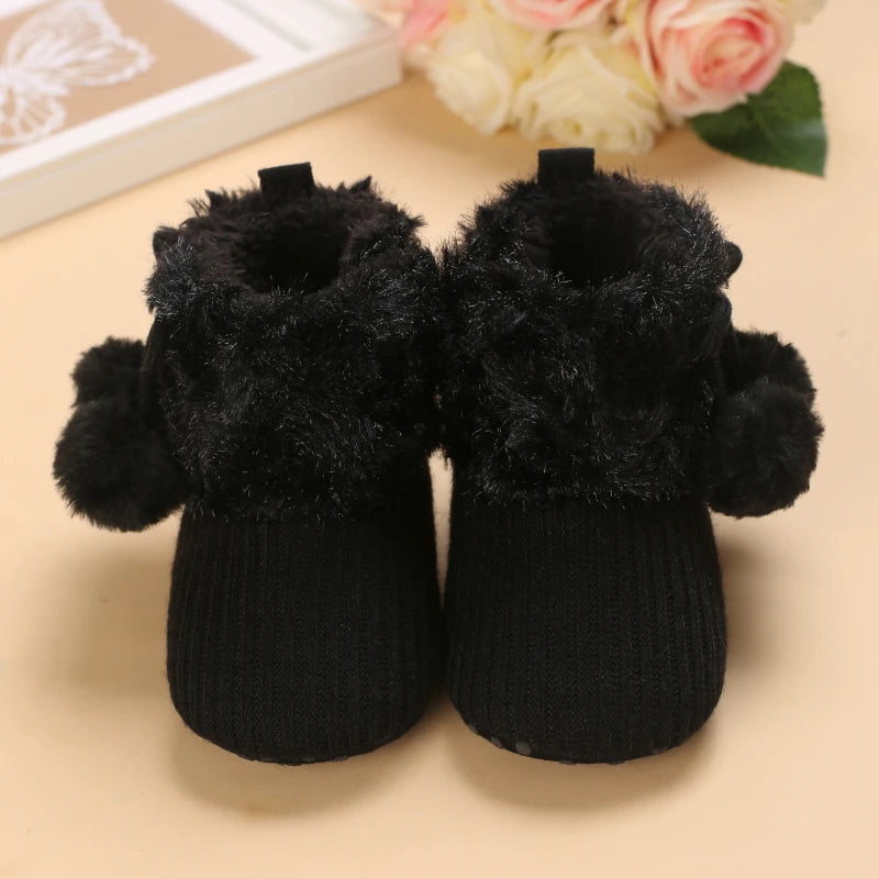 Semelle antidérapante des bottines bébé noires, fourrure et tricot épais.
