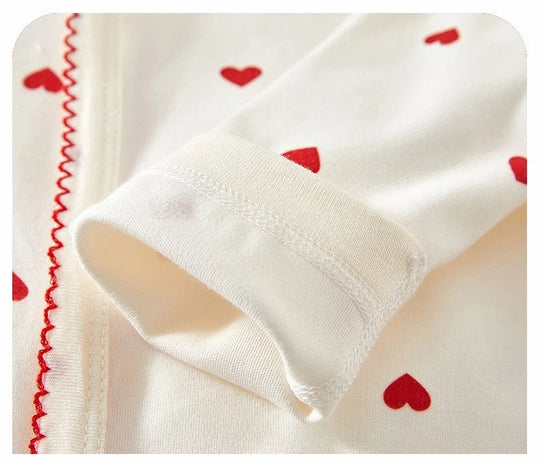 « Détail des manches en coton de la barboteuse bébé à cœurs rouges – Kalinatur »