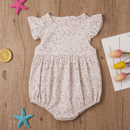 Barboteuse bébé fille fleurie beige en coton avec manches à volants et boutons, vêtement été élégant pour nourrisson de 0 à 24 mois.