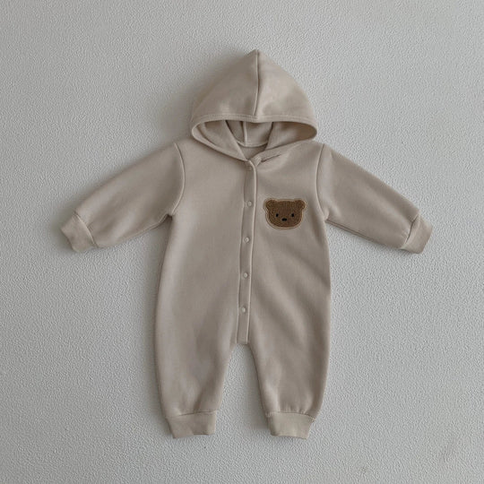 Combinaison bébé beige avec capuche et motif ourson sur la poitrine, vêtement doux et chaud.