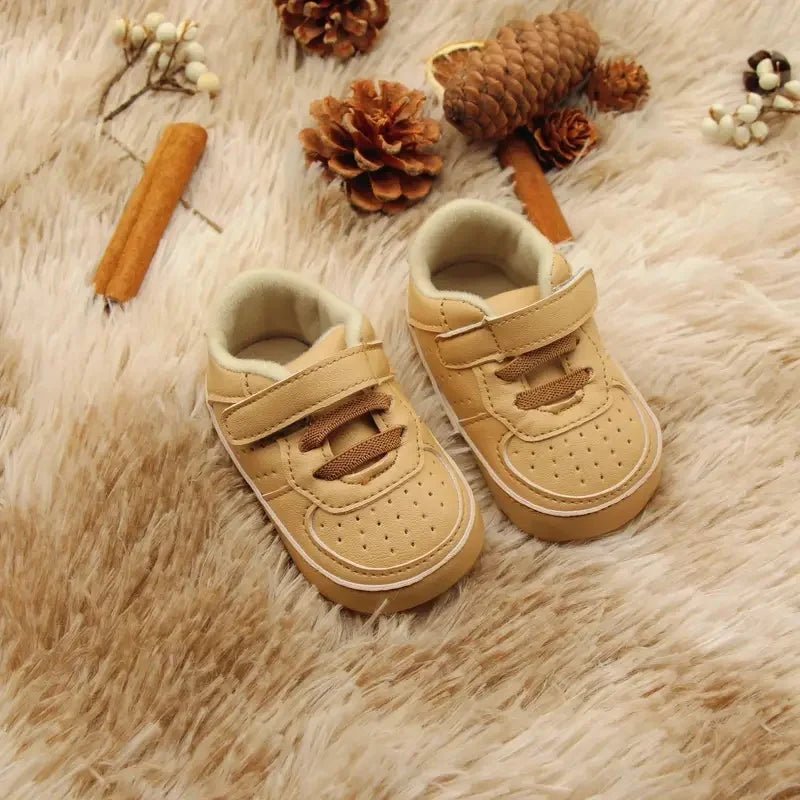 Chaussures premiers pas bébé couleur beige camel, semelle souple et design cocooning, parfaites pour le confort des tout-petits.

