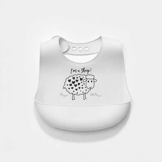Bavoir bébé en silicone blanc avec poche récupératrice, décoré d’un mouton avec des cœurs et du texte “I’m a sheep”, sur fond blanc