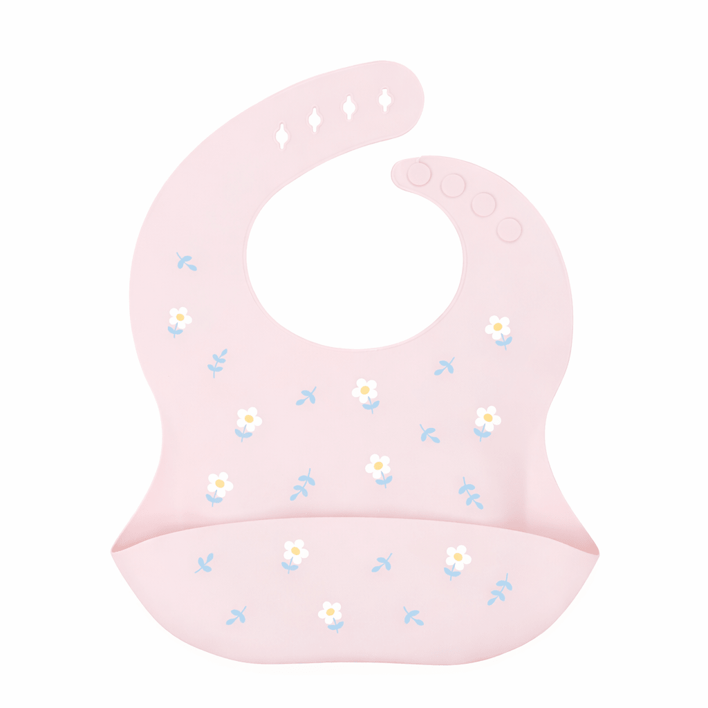 Bavoir bébé en silicone rose avec poche récupératrice, décoré de petites fleurs blanches et feuilles bleues, sur fond blanc