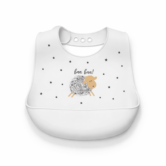 Bavoir bébé en silicone blanc avec poche récupératrice, décoré d’un mouton et de petites étoiles noires, sur fond blanc
