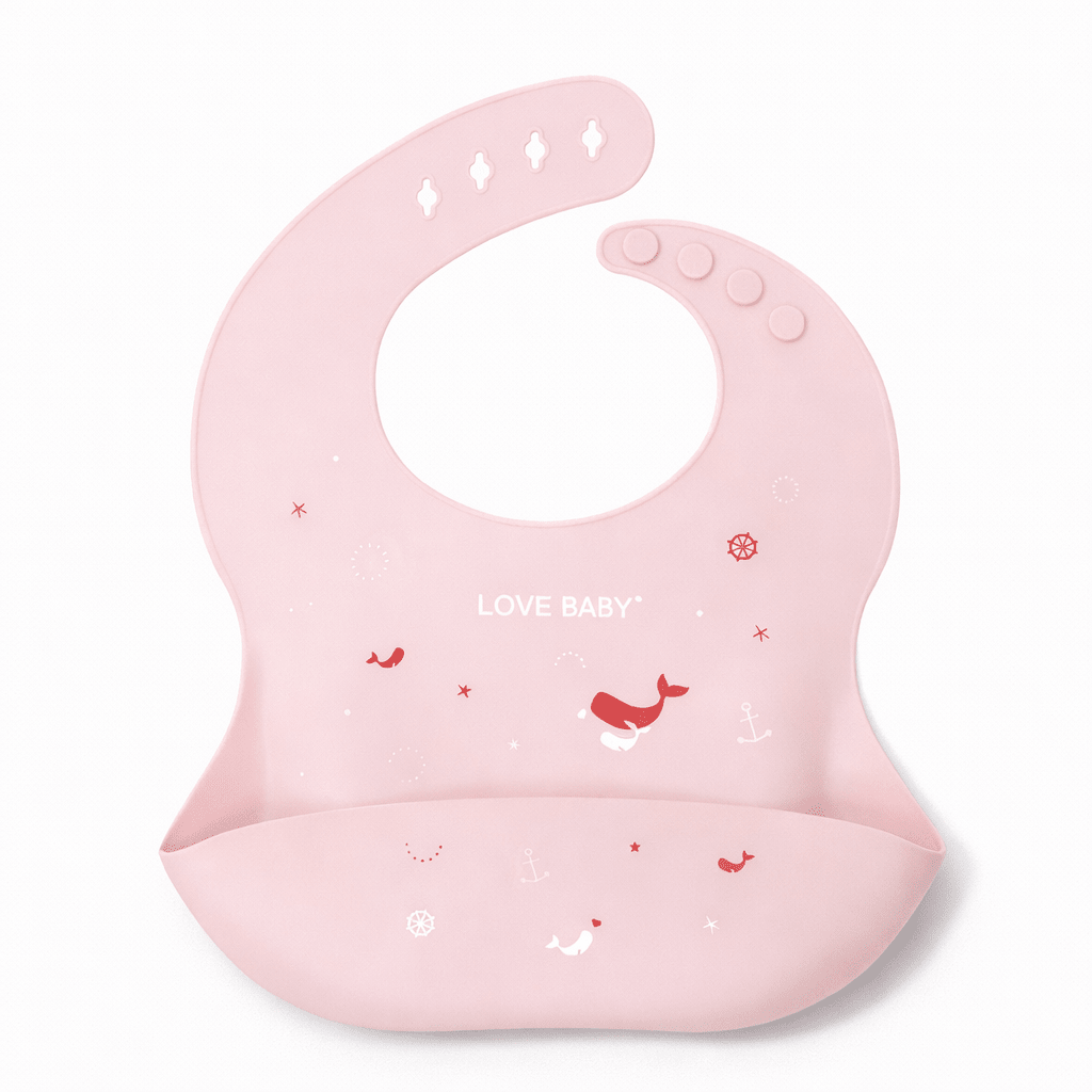 Bavoir bébé en silicone rose avec poche récupératrice, décoré de motifs marins (baleines, ancres) et texte “Love Baby”, sur fond blanc