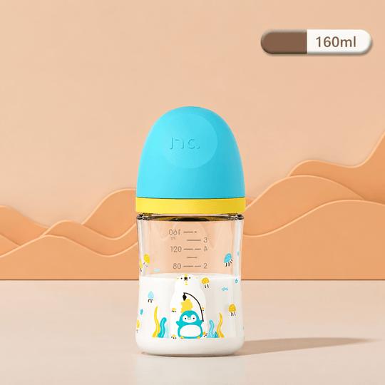 Biberon en verre pour bébé de 160 ml avec capuchon bleu turquoise et jaune, décoré d’un pingouin et d’un ours polaire. Biberon anti-colique transparent présenté sur un fond beige dans une mise en scène professionnelle et épurée