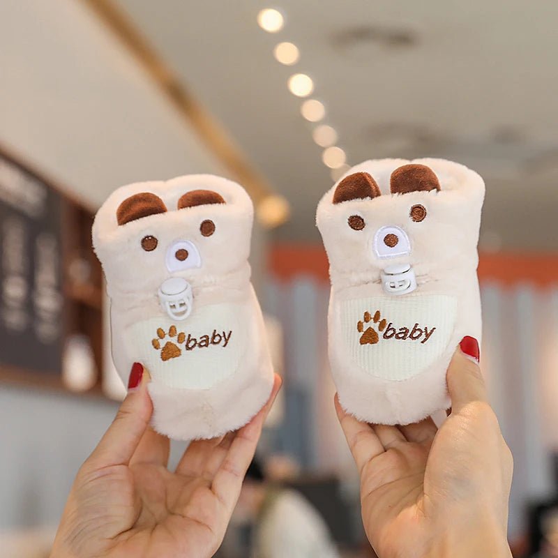 Chaussons bébé en fausse fourrure crème, détails brodés adorables, design léger et chaud. Parfait pour les tout-petits en hiver.