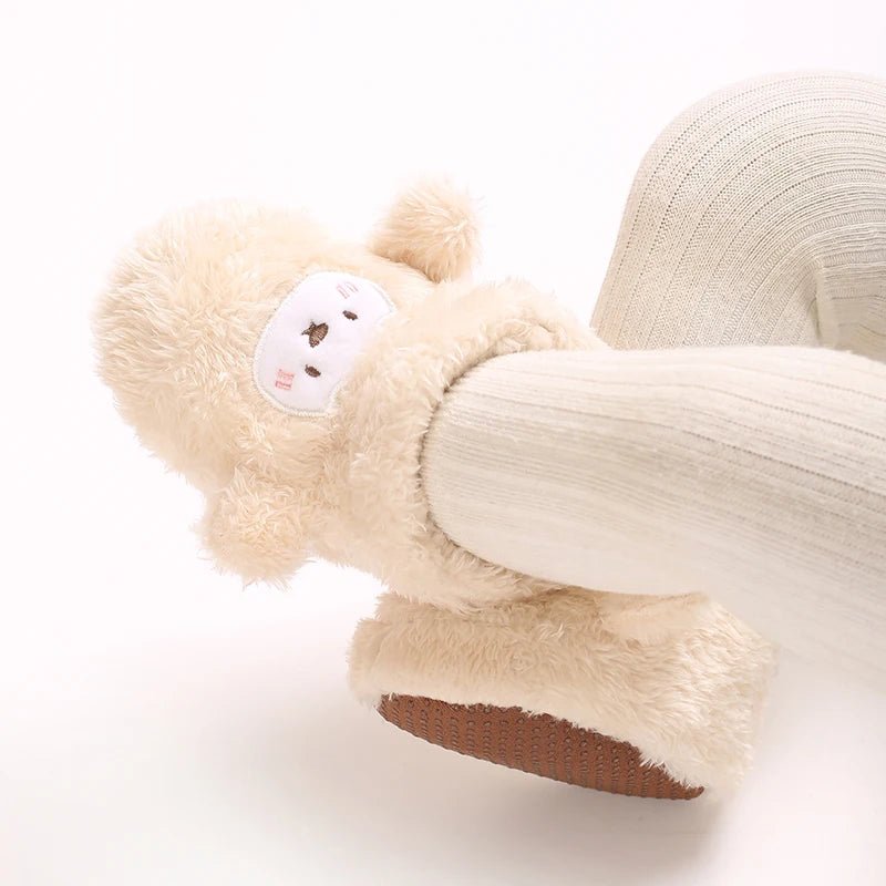 Bottines doudou crème avec motif ours brodé et semelle antidérapante. Ultra-chaudes, moelleuses et parfaites pour les petits explorateurs.