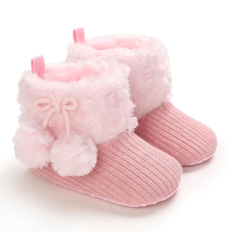 Bottines bébé rose poudré avec fourrure blanche et pompons, modèle chaud et antidérapant.