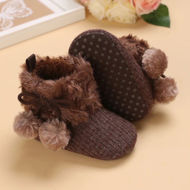 Bottines bébé brun noisette avec fourrure caramel, pompons et semelle antidérapante à pois.