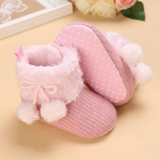 Bottines bébé rose sucre avec fourrure blanche et pompons, semelle douce à pois.