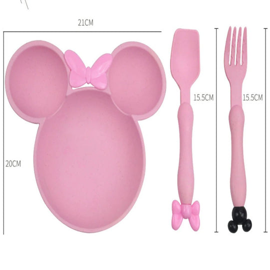Assiette pour enfant en forme de tête de souris rose avec compartiments, accompagnée d’une cuillère et d’une fourchette assorties. Les dimensions du produit sont indiquées sur l’image, sur fond blanc.
