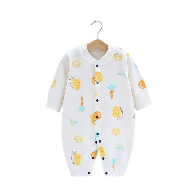 Combinaison bébé blanche ornée de motifs citron, orange, carotte et petits dessins colorés, fermeture à boutons sur le devant, tissu léger et respirant.