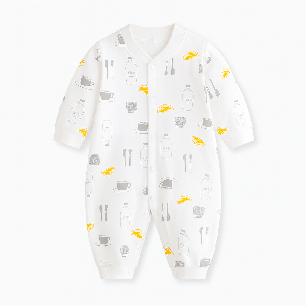 Combinaison bébé blanche décorée de motifs tasses, bouteilles de lait, cuillères et petits fruits jaunes, style gourmand et original.