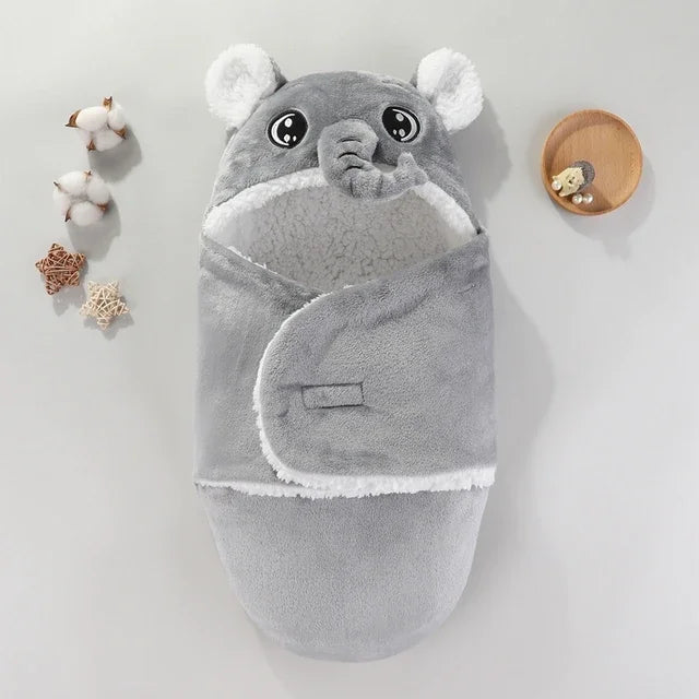 Couverture bébé grise en forme d’éléphant avec capuche et trompe 3D, intérieur blanc en tissu doux et chaud, accessoire cocooning Kalinatur idéal pour envelopper bébé.
