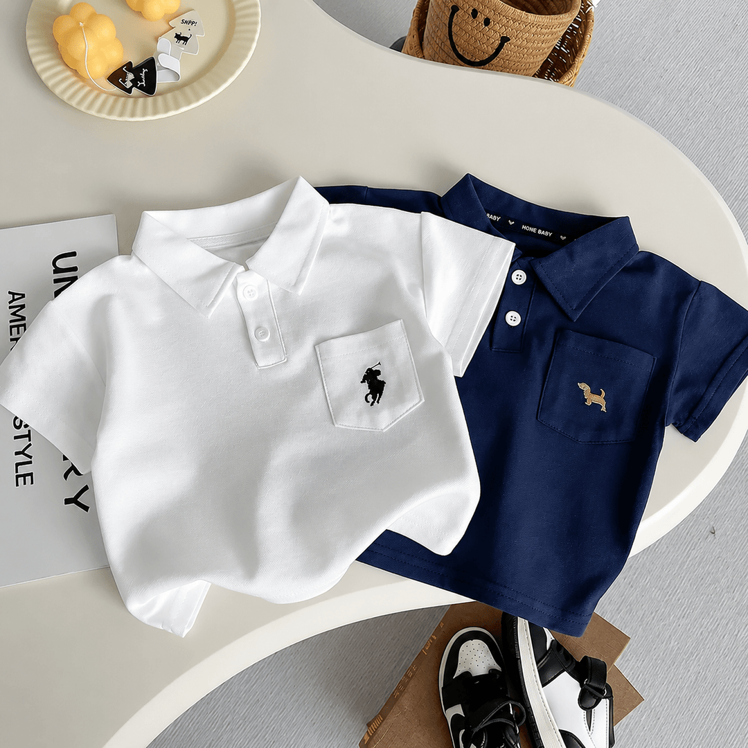 Ensemble polo bébé garçon composé de deux polos à manches courtes blanc et bleu marine avec short beige imprimé, tenue élégante et confortable pour l&