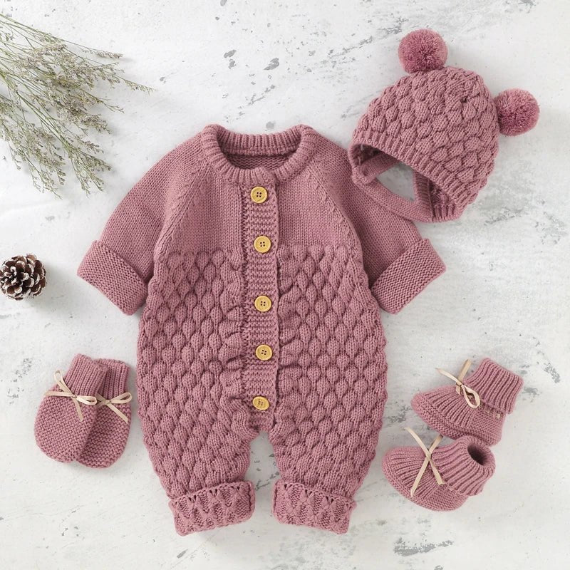 Ensemble tricot rose poudré pour bebe avec combinaison a boutons, bonnet a pompons et chaussons assortis, photographie ambiance douce et hivernale KaliNatur.
