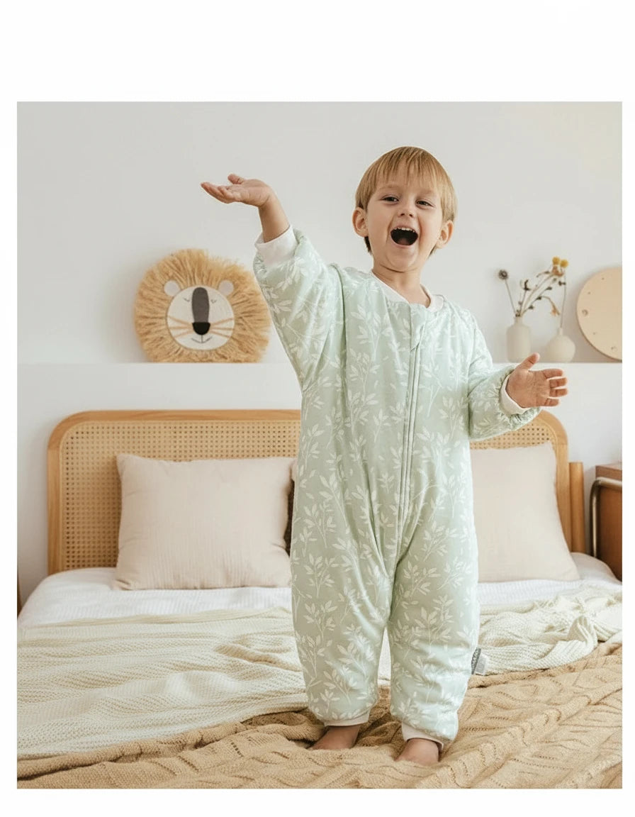 Bébé portant une gigoteuse à jambes Kalinatur vert doux imprimée de petites branches blanches, confortable et chaude pour un sommeil paisible.
