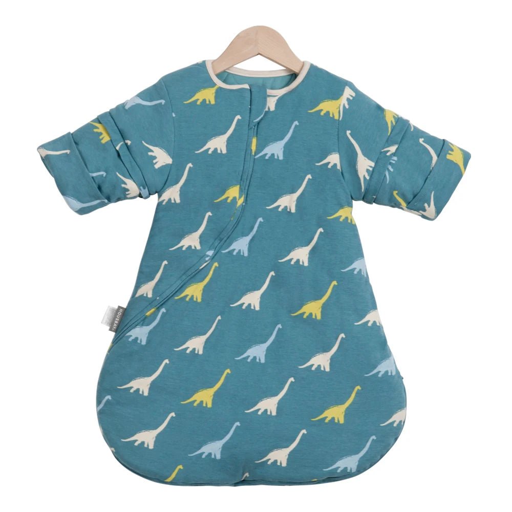 Gigoteuse d’hiver pour bébé Kalinatur, bleue avec motifs de dinosaures jaunes, blancs et bleus, manches longues amovibles, tissu doux et chaud pour un sommeil confortable.
