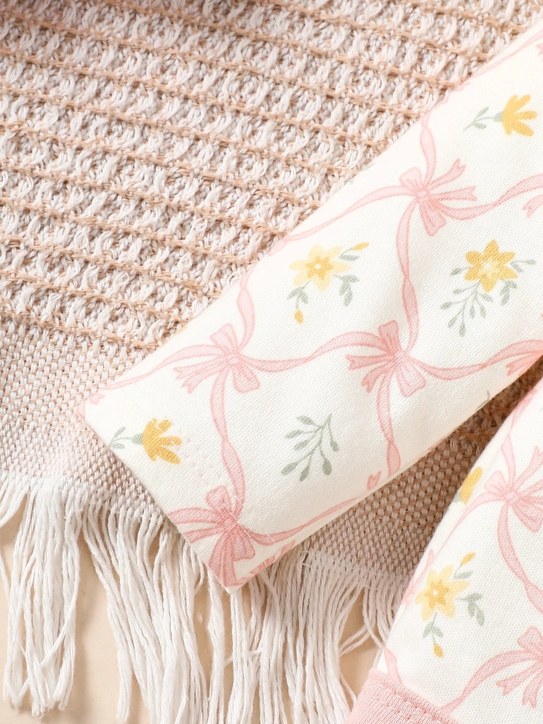 Détail des manches d’un body bébé à motifs fleurs roses et jaunes, tissu doux et imprimé délicat Kalinatur.