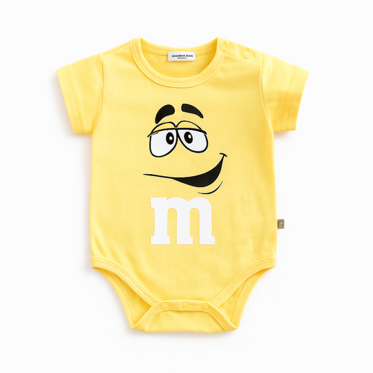 Body bébé jaune inspiré du M&M’s jaune avec grand sourire et expression joyeuse, vêtement coloré pour bébé.