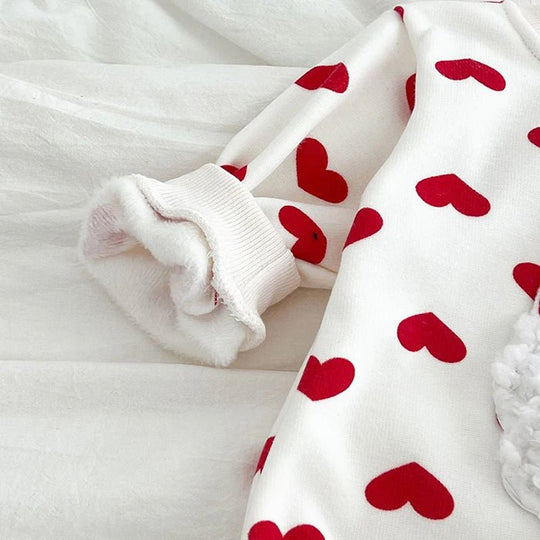 Détail du bas du body bébé blanc Kalinatur décoré de cœurs rouges, avec finition côtelée au niveau de la jambe.