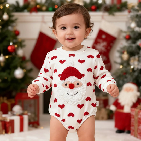 Bébé portant un body blanc Kalinatur à manches longues décoré de cœurs rouges et d’un motif Père Noël.