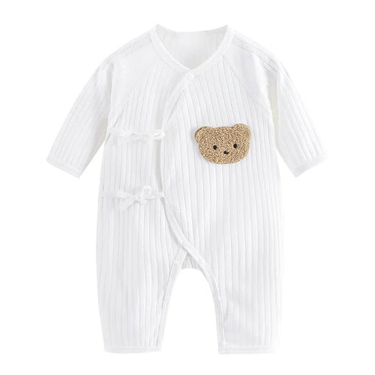 Combinaison bébé blanche côtelée avec liens croisés et patch ourson beige.