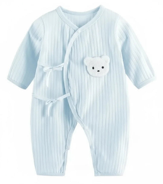 Combinaison bébé bleu pastel côtelée avec liens croisés et patch ourson blanc.