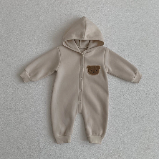 Combinaison bébé beige avec capuche et motif ourson sur la poitrine, vêtement doux et chaud.