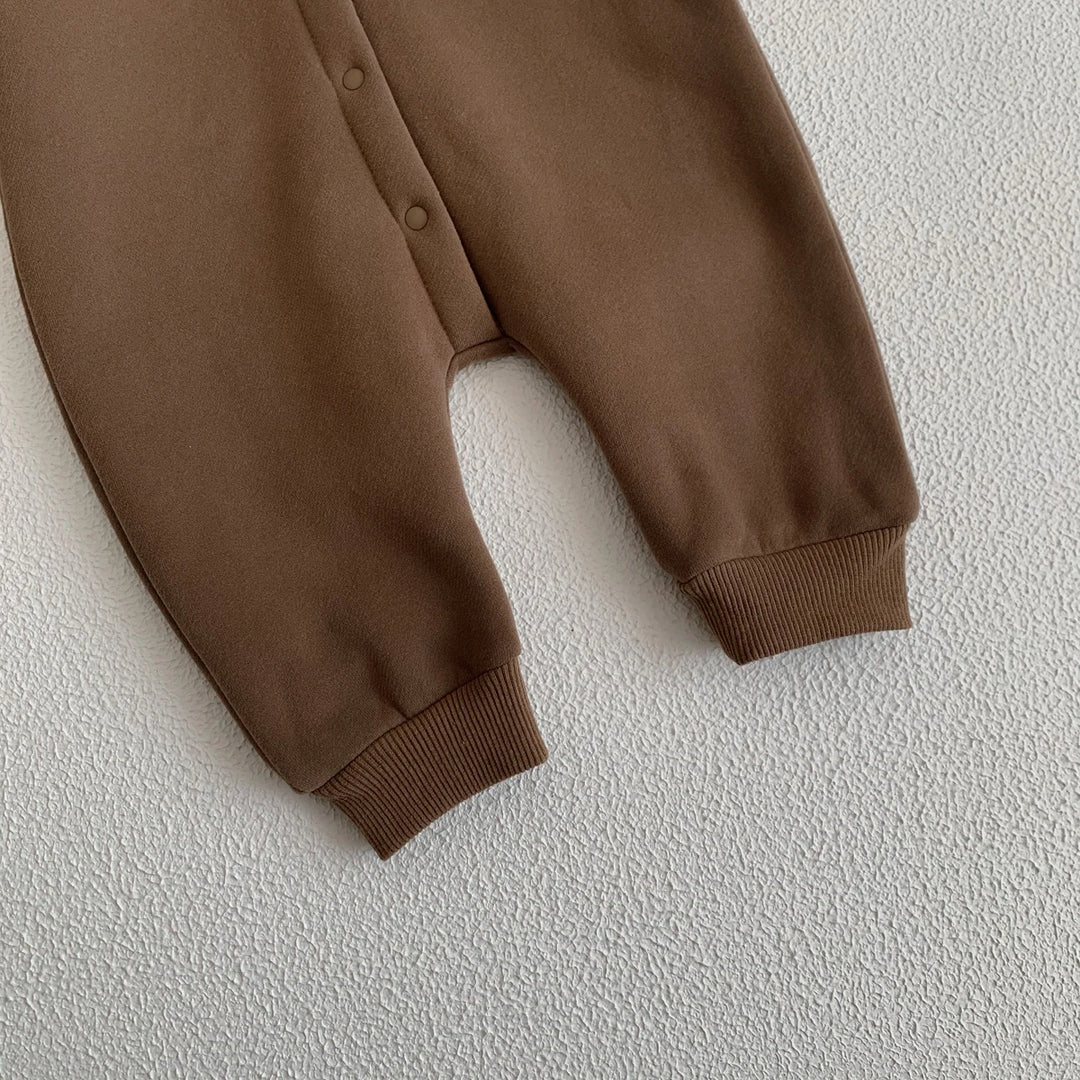 Bas de la combinaison bébé marron avec boutons-pressions et chevilles resserrées.