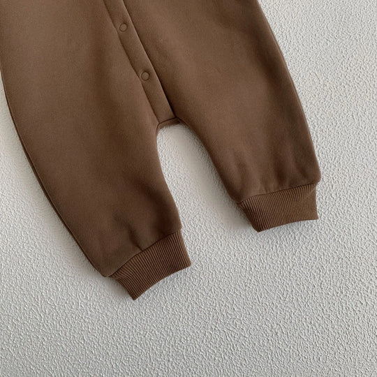 Bas de la combinaison bébé marron avec boutons-pressions et chevilles resserrées.