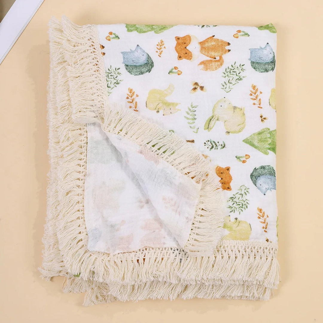 Couverture légère pour bébé Kalinatur, motif animaux de la forêt pastel avec bordure à franges bohème.