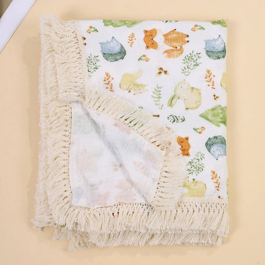 Couverture légère pour bébé Kalinatur, motif animaux de la forêt pastel avec bordure à franges bohème.