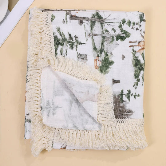 Couverture légère pour bébé Kalinatur avec motif forêt et animaux, bordure à franges crème.