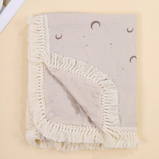 Couverture légère pour bébé Kalinatur avec motifs lune bohème et bordure à franges crème.

