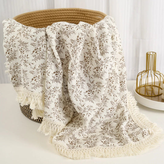 Couverture légère pour bébé Kalinatur en mousseline, motif floral beige avec franges décoratives.