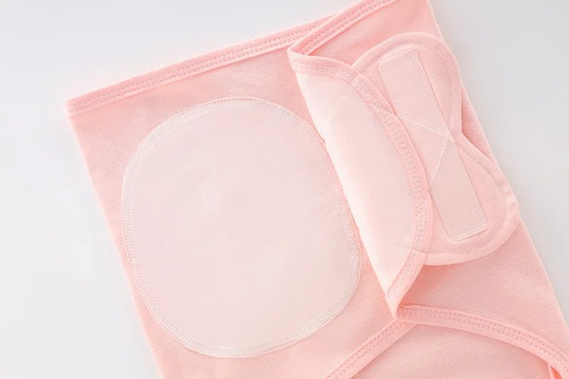 Gros plan sur les attaches et la fermeture Velcro du nid d’ange rose pâle pour nouveau-né.