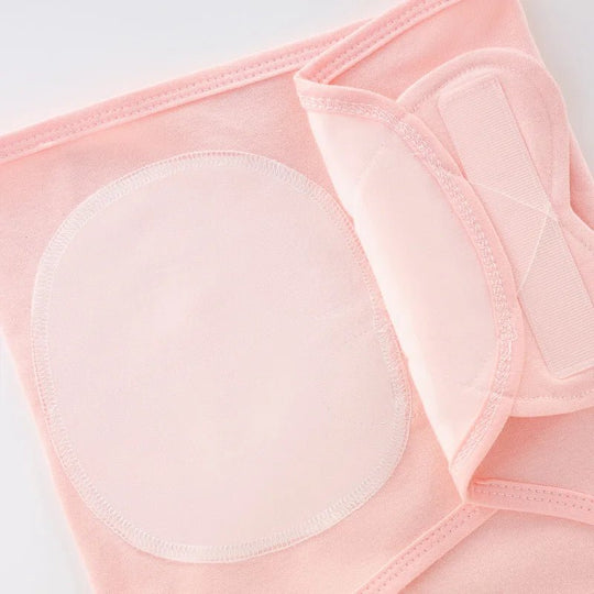 Gros plan sur la fermeture croisée du nid d’ange rose pâle pour nouveau-né, montrant les coutures et les attaches en tissu doux.