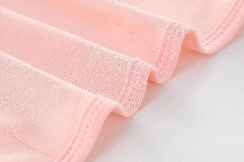 Gros plan sur les coutures du tissu rose du nid d’ange, montrant la texture douce et la finition soignée.