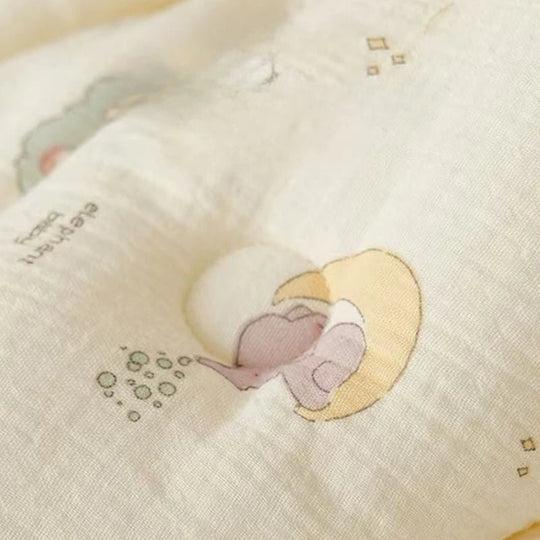 Motif éléphant imprimé sur une mousseline de coton ivoire pour bébé, présenté en gros plan dans un décor doux Kalinatur.