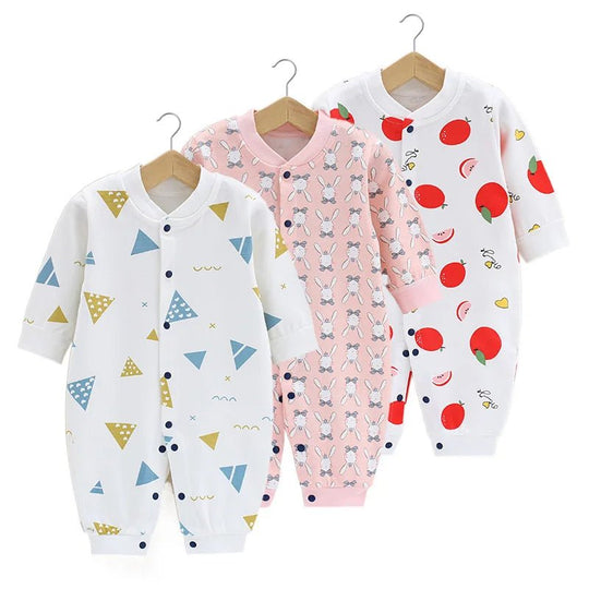 Lot de trois pyjamas bébé : un imprimé triangles graphiques jaune et bleu, un rose avec lapins blancs répétés, et un blanc décoré de grandes pommes rouges.