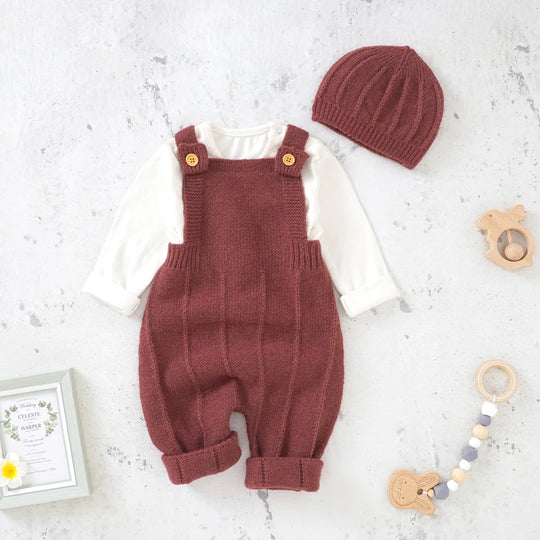Tenue bébé en tricot bordeaux composée d’une salopette chaude et d’un bonnet.