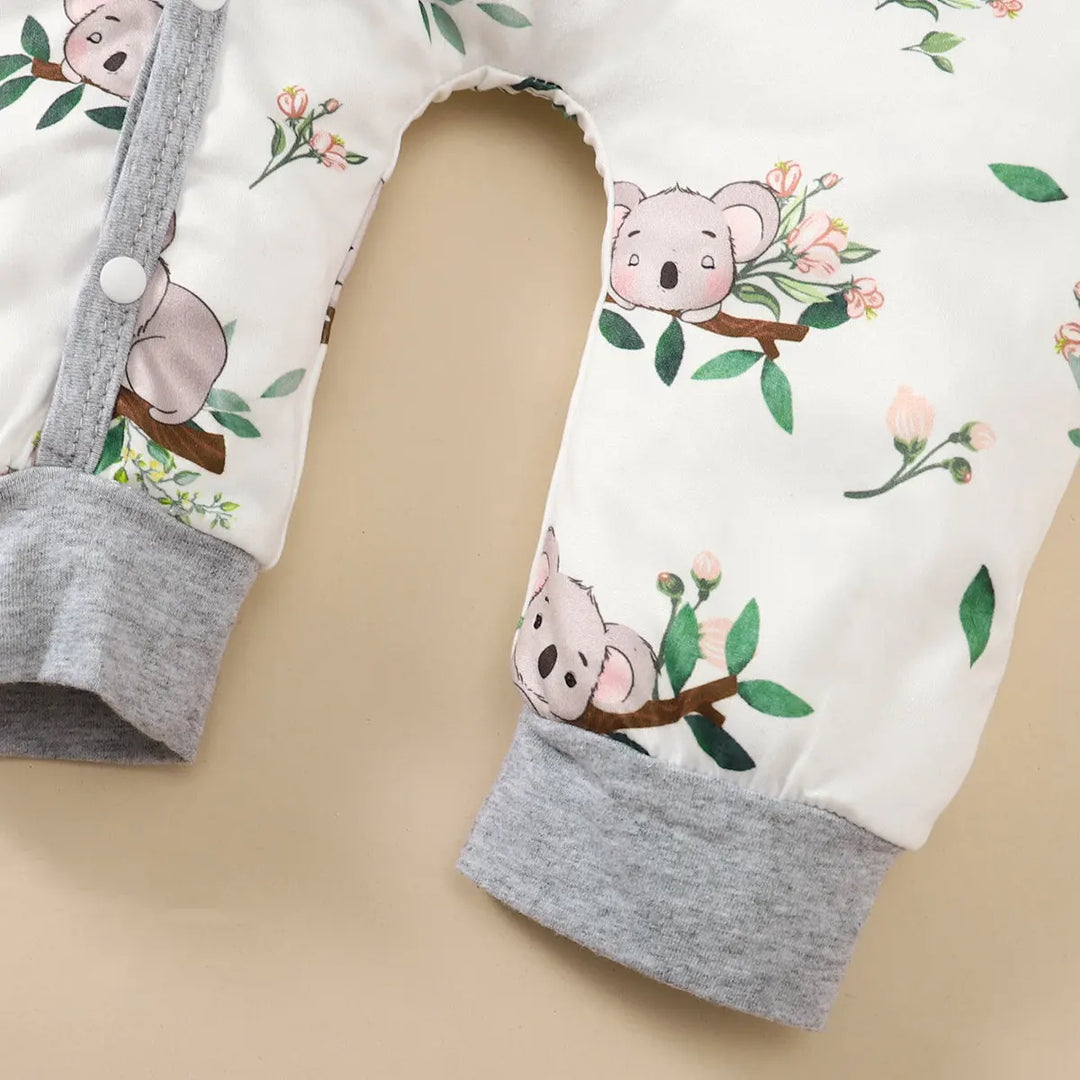 Détail du pyjama bébé Kalinatur avec imprimé koala sur fond blanc et poignets gris, en coton doux et respirant pour le confort des tout-petits.