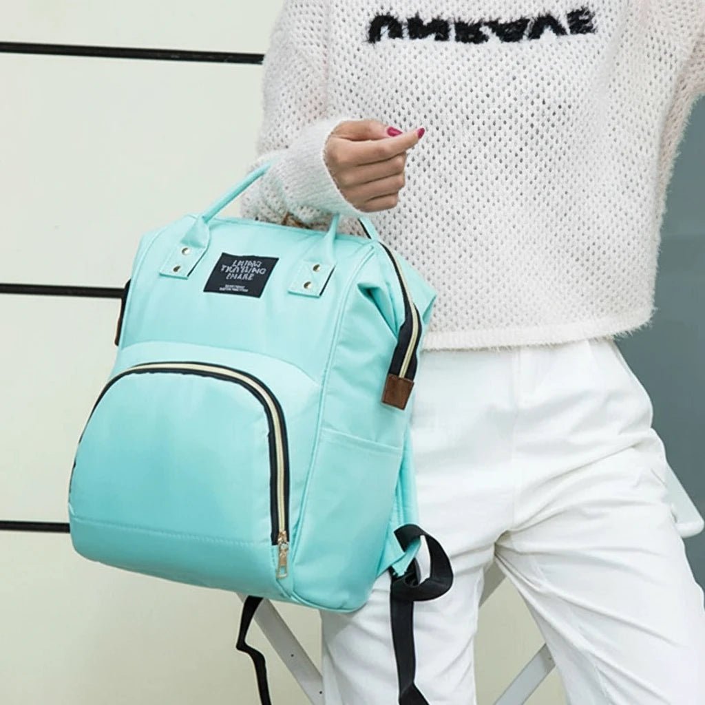 Sac à dos à langer vert menthe Kalinatur porté par une maman, style moderne et pratique.