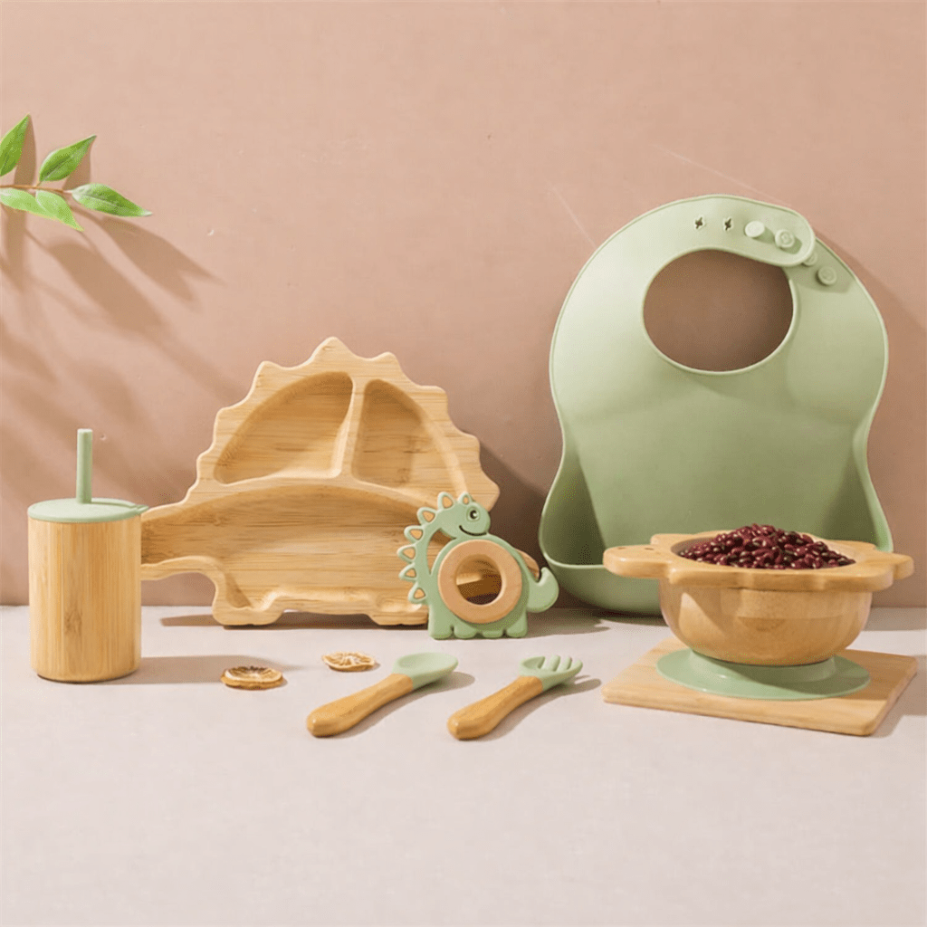 Set repas bébé en bambou et silicone vert comprenant assiette dinosaure compartimentée, bol, bavoir, tasse avec paille, cuillère, fourchette et anneau de dentition pour enfants jusqu’à 5 ans
