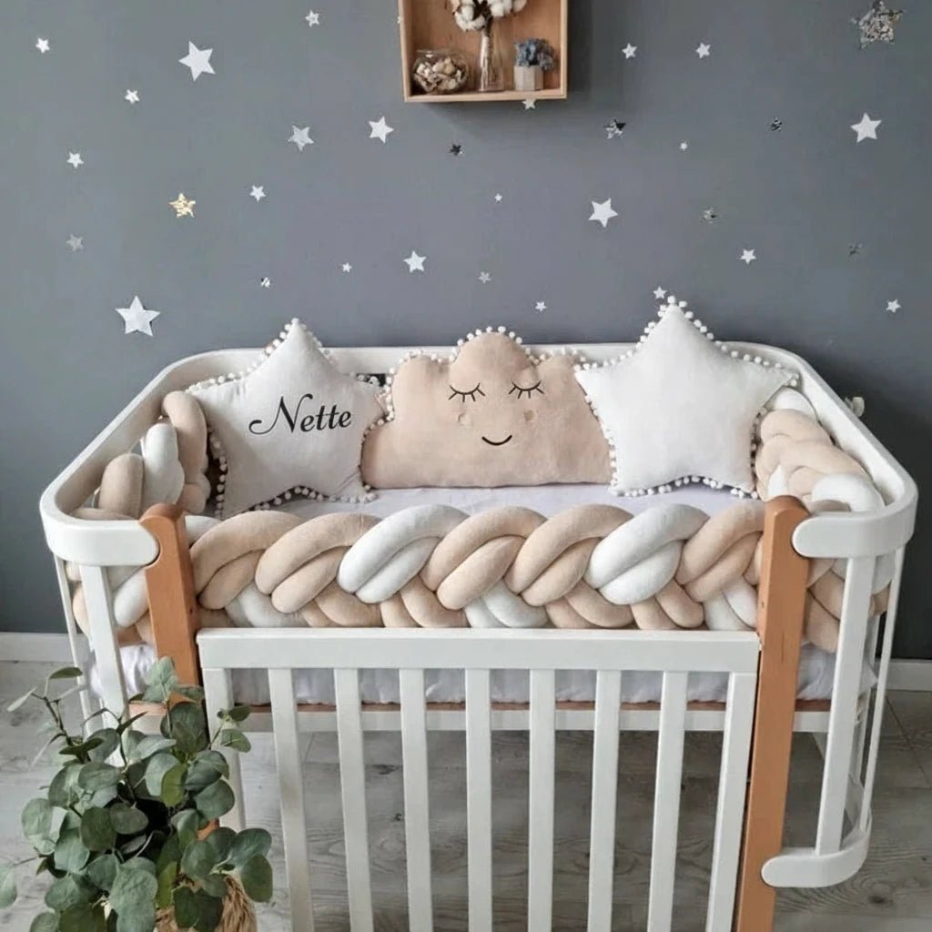 Berceau bébé Kalinatur™ avec tresse de lit beige et blanche, coussins en forme d’étoile et de nuage, ambiance cocooning et décor étoilé pour chambre de bébé.