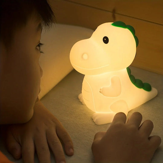 Enfant regardant une veilleuse bébé dinosaure allumée sur la table de nuit – lumière douce et apaisante pour favoriser l’endormissement – Kalinatur™
