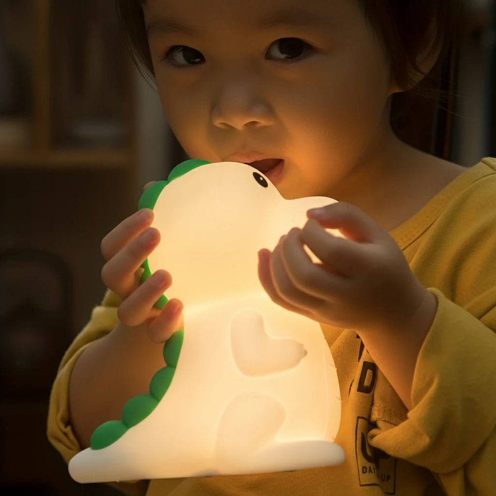 Enfant tenant une veilleuse bébé en forme de dinosaure – lumière douce et rassurante pour l’endormissement – produit Kalinatur™
