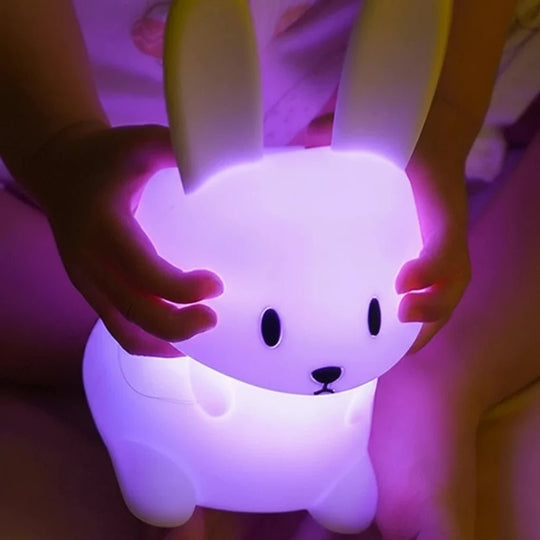 Enfant tenant une veilleuse bébé lapin violette – lumière douce et sécurisante pour l’endormissement – produit Kalinatur™